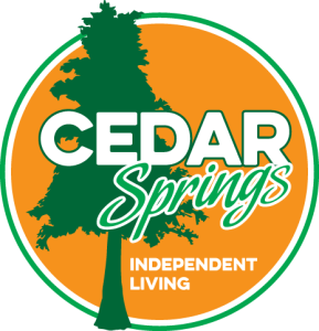 Cedar Springs Independent Living logo with a green tree silhouette over an orange circle and bold white 'CEDAR Springs' text and 'Independent Living' at the bottom.